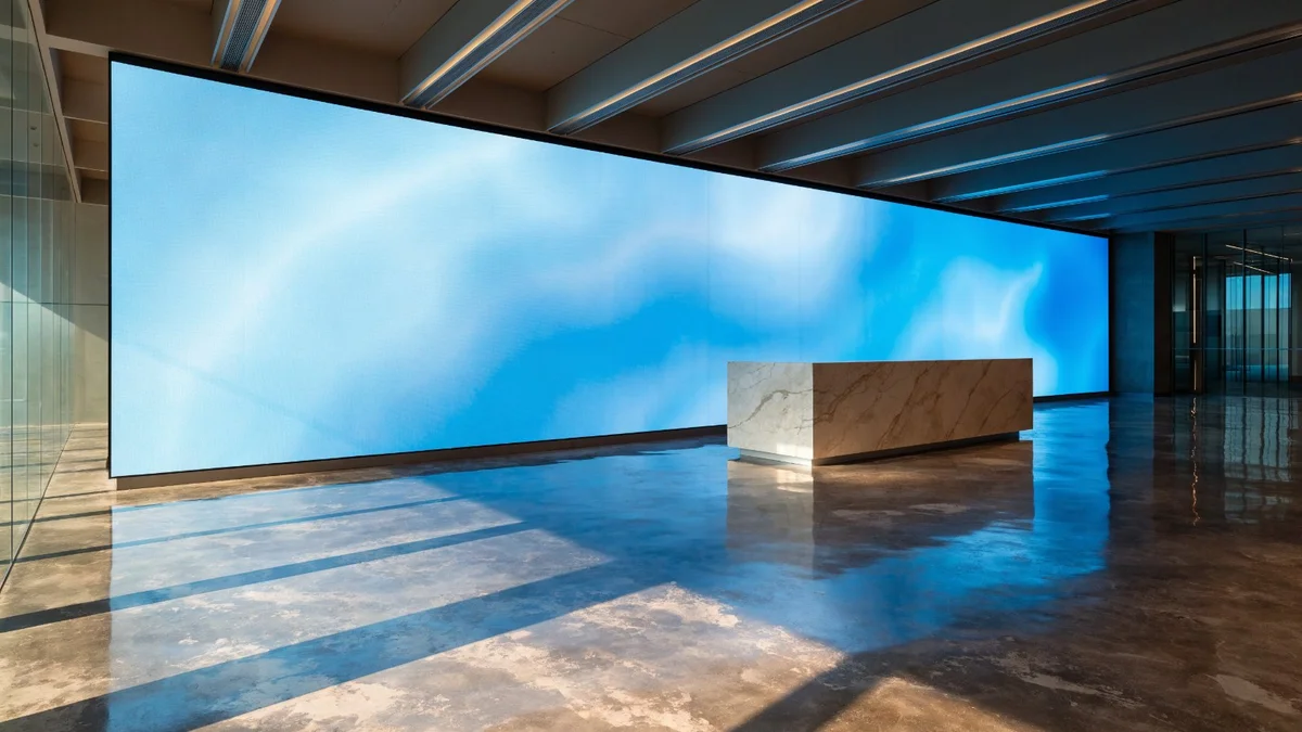 Mur LED sans bordure occupant la paroi principale d'un hall d'accueil d'entreprise, en dégradé bleu