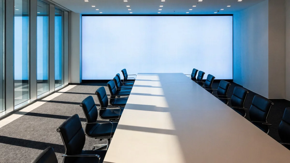 Écran LED continu en bout de table dans une salle de réunion d'entreprise vitrée
