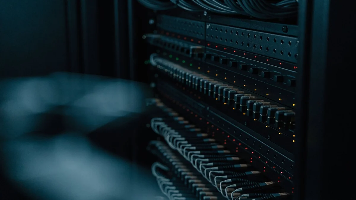 Baie de processeurs vidéo professionnels au format rack, voyants allumés et câblage réseau