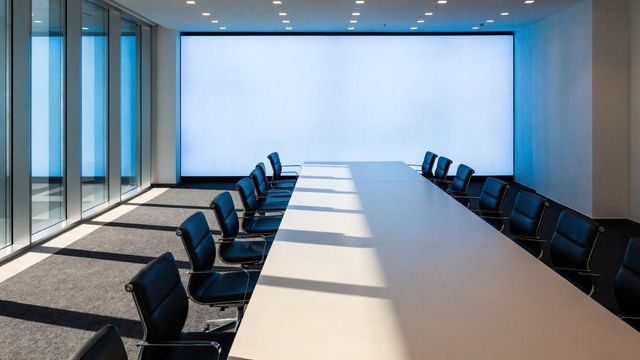 Écran LED continu en bout de table dans une salle de réunion d'entreprise vitrée