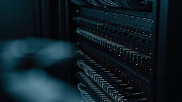 Baie de processeurs vidéo professionnels au format rack, voyants allumés et câblage réseau